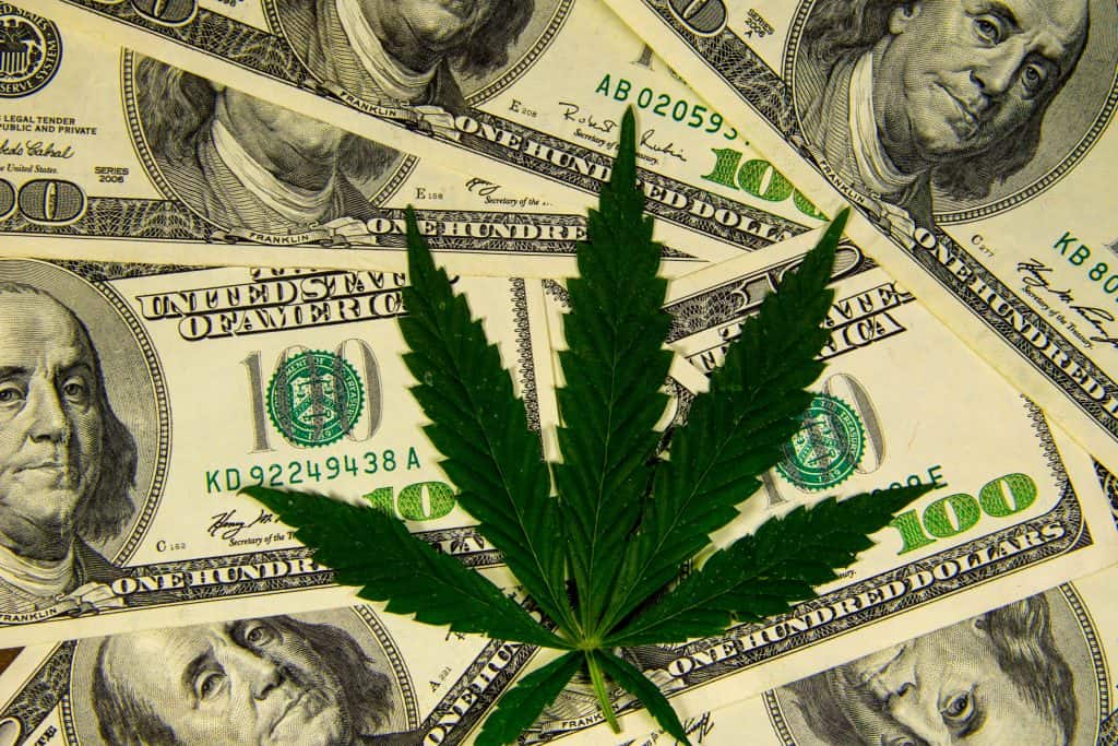 Image of a marijuana leaf over money