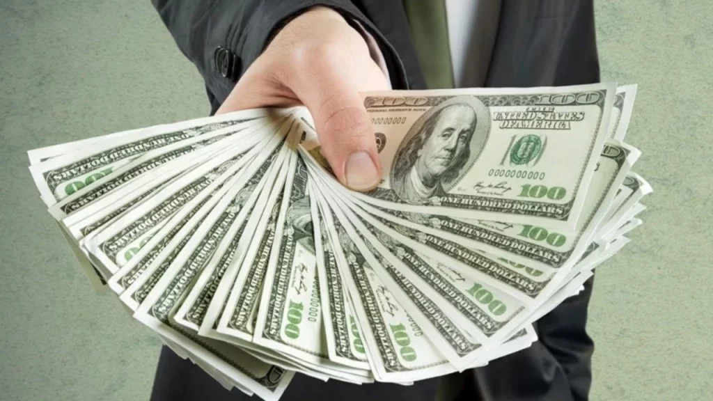Image of a businessperson fanning out $100 bills
