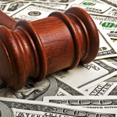 Image of a judge's gavel sitting on a pile of cash