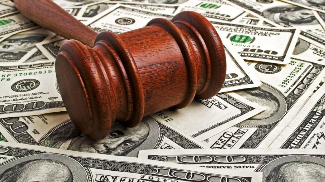 Image of a judge's gavel sitting on a pile of cash