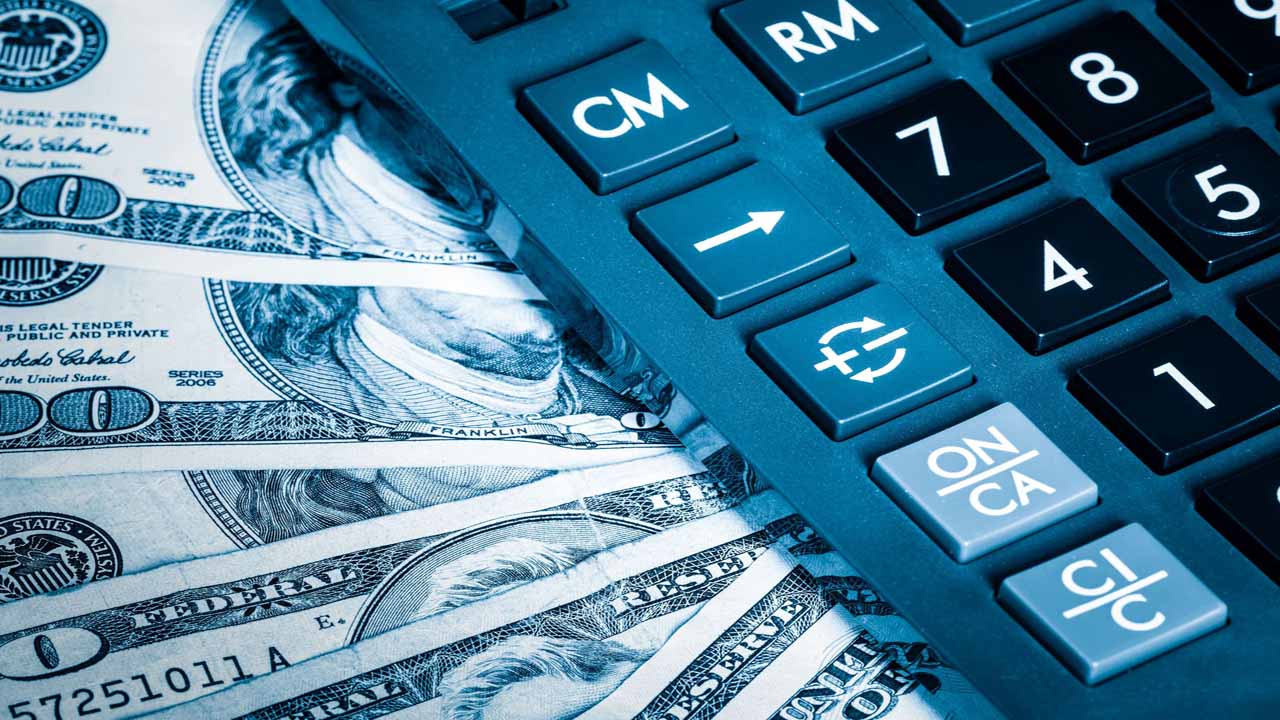 Image of a calculator sitting atop fanned out cash
