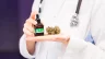 Image of a physician holding a marijuana bud and cannabis oil