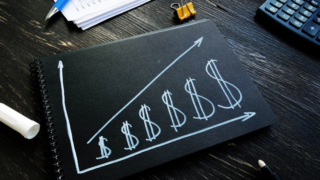 Image of dollar signs on a chalkboard increasing in size, left to right