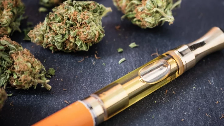 Image of a vape pen and marijuana buds