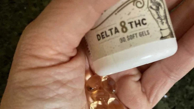 Image of a hand holding delta-8 THC gel caps