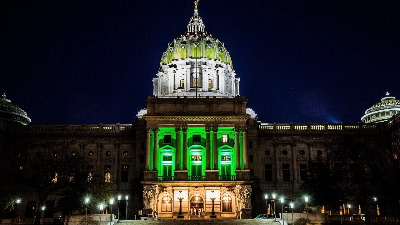 Image of the Pennsylvania state capitol building lighted in green