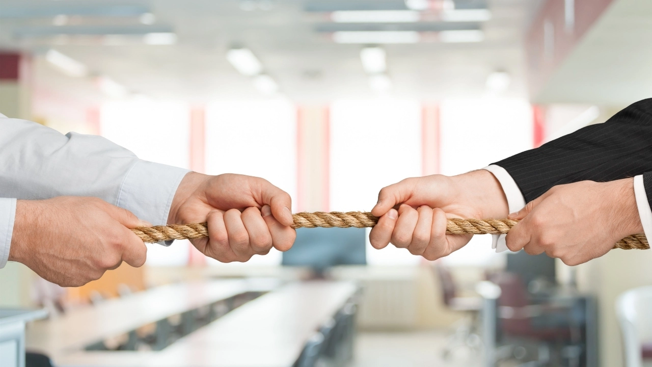 Image of two executives playing tug of war with a rope