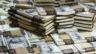 Image of $100 bills in $5,000 bundles.
