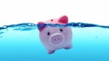 Image of a pink piggy bank drowning in debt 
