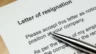 Image of a pen sitting atop a resignation letter