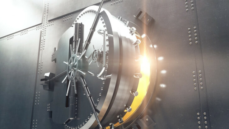 Image of a partially open bank vault door with a glowing light emanating from within