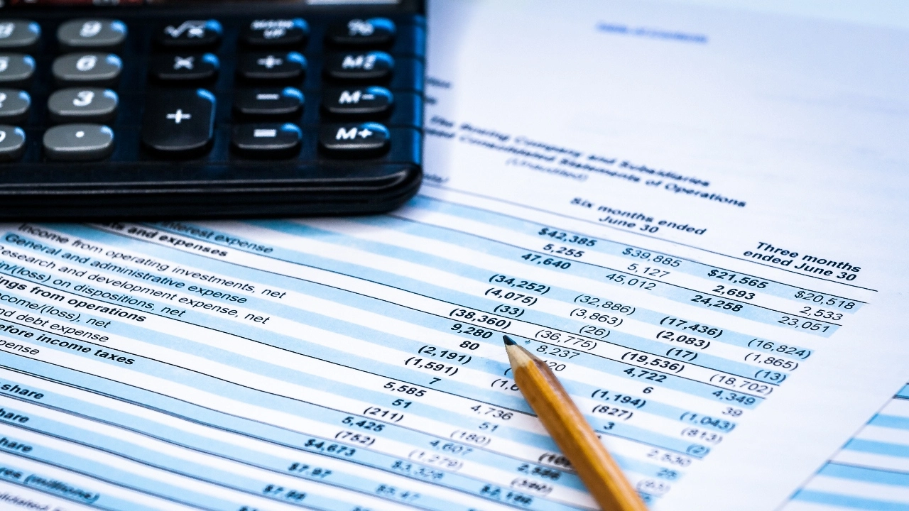 Image of a calculator and pencil sitting atop earnings statements