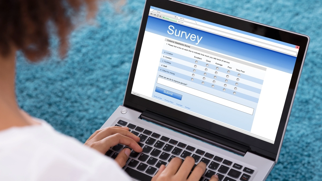 Image of a woman taking a survey on a laptop