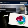 Image of a person holding a mobile phone bearing the seal of the U.S. Drug Enforcement Administration with the DEA's website in the background