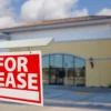 Image of a "For Lease" sign in front of a vacant business space