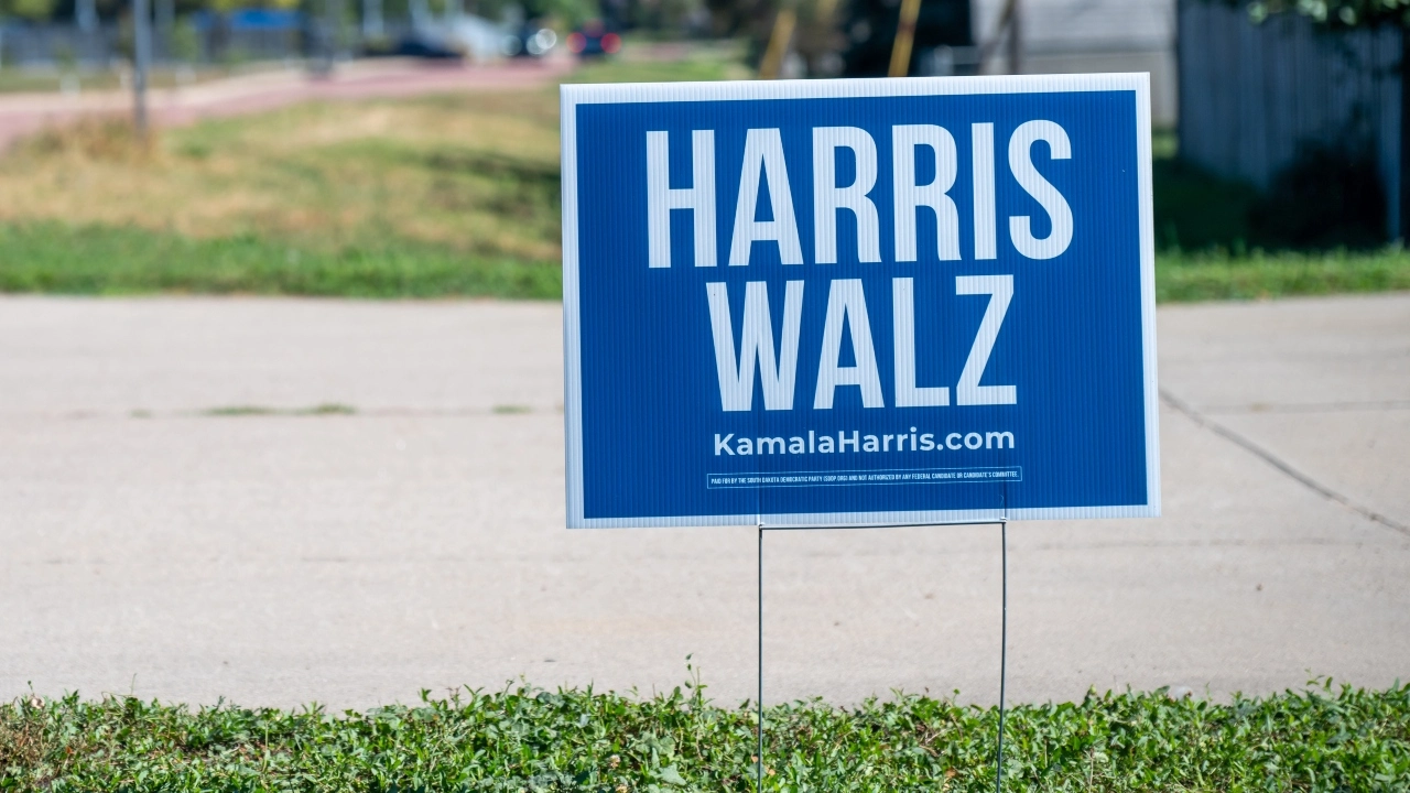 Image of a Kamala Harris-Tim Walz campaign sign in a yard near a driveway