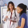 Image of Asian doctor holding a tablet while talking with an African American patient