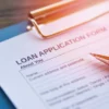 Image of a pen sitting atop a loan application form