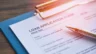 Image of a pen sitting atop a loan application form