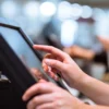 Image of a woman's hands processing a payment on a touchscreen point-of-sale system