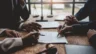 Image of businesspeople and attorneys negotiating terms of a contract