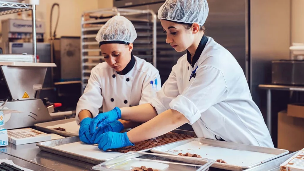 Image of employees arranging infused chocolates before packaging