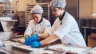 Image of employees arranging infused chocolates before packaging
