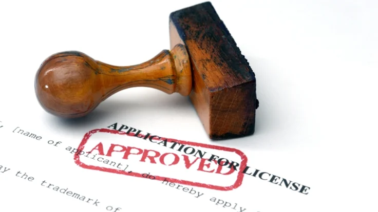Inage of an APPROVED stamp lying on its side atop a trademark license application