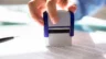 Image of a woman stamping approval on a business