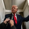 President Donald Trump addresses reporters on Air Force One.