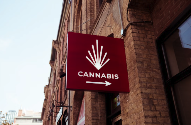 Cannabis retail store exterior sign on brick building facade